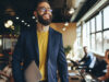 Homme souriant avec un ordinateur portable sous le bras