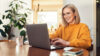 Moderne Maklerin vor Laptop in Büro